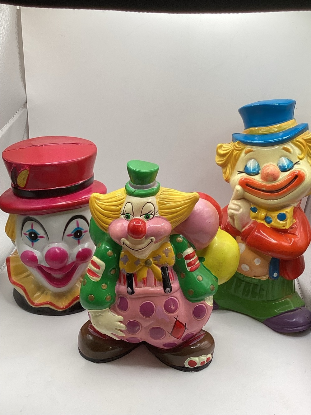 Three vintage 1980s hard plastic circus clown coin banks